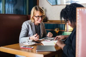 Workshop "Frauen ticken anders", Zwei Frauen sitzen an einem Tisch und trinken Kaffee