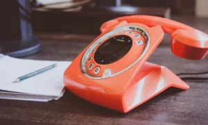 rotes kabelgebundenes Vintage Telefon mit Wählscheibe